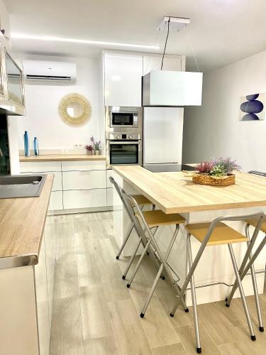 a kitchen with a wooden table and chairs at Blue house 1ª linea playa in Torrevieja