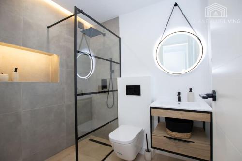łazienka z toaletą, umywalką i lustrem w obiekcie Scandinavian style apartment with sea views in a beachfront urbanisation in Calahonda 15 minutes from center of Marbella! w mieście Sitio de Calahonda