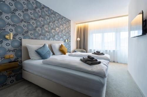 ein Schlafzimmer mit einem großen weißen Bett mit einer Wand in der Unterkunft zum Sausaler - Boutique Hotel-Pension Südsteiermark in Sankt Nikolai im Sausal