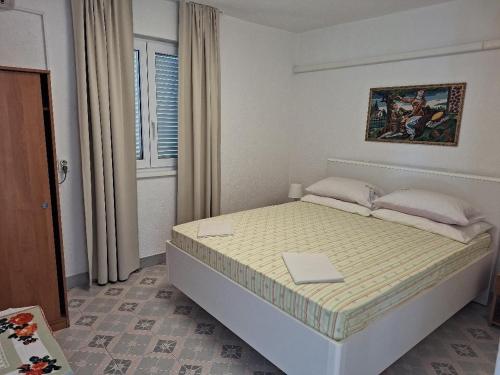 um quarto com uma cama com um computador portátil em Apartments with a parking space Pisak, Omis - 4281 em Mimice