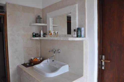 ein Bad mit einem Waschbecken und einem Spiegel in der Unterkunft Secluded holiday house Stokic Pod, Velebit - 21524 in Jablanac