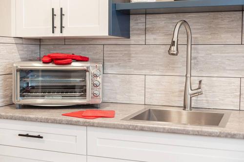 a kitchen with a sink and a toaster oven at RainCoast Retreat at Shawnigan Lake! in Shawnigan Lake