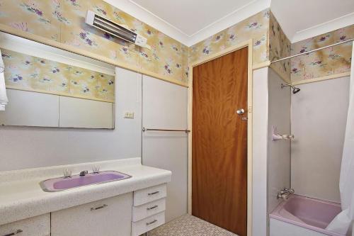 La salle de bains est pourvue d'un lavabo rose et d'une douche. dans l'établissement Lake Frontage, à Lake Tabourie