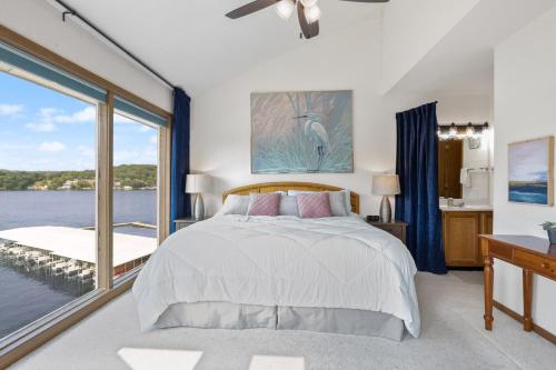 a bedroom with a bed and a view of the water at Heron Way in Osage Beach