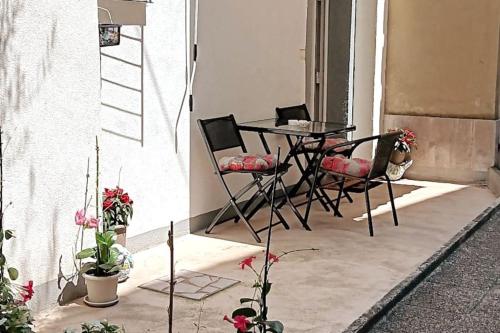 een patio met een tafel en stoelen en een aantal planten bij Lovely apartment Morje - Koper old town in Koper