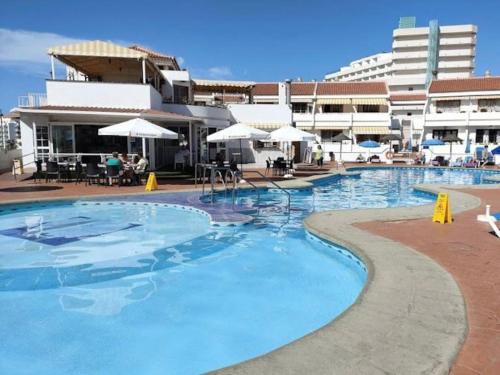 a large swimming pool in front of a building at Apartamento Lucía Garden City con piscina climatizada in Playa Fañabe