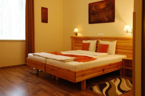 a bedroom with a wooden bed in a room at Hotel Manzard Panzio in Budapest