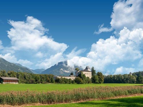 a large building in a field with mountains in the background at Attractive apartment with terrace in Kirchbichl