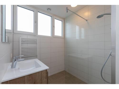 une salle de bain blanche avec un lavabo et une douche dans l'établissement Holiday Home near Beach Burgh-Haamstede, à Burgh-Haamstede