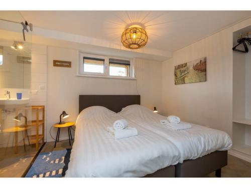een slaapkamer met een bed met twee handdoeken erop bij Detached holiday home in a wooded area near the beach in Burgh Haamstede