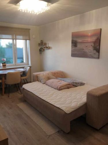 a bedroom with a bed and a table and a window at Rannarajooni holiday apartment in Pärnu