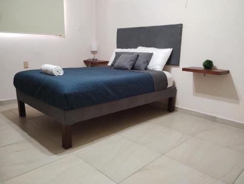 - un lit avec une couverture bleue et des oreillers dans l'établissement Departamento México, à Tampico