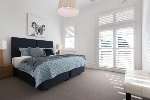 a bedroom with a bed and a couch and windows at Barwidgee in Hepburn Springs