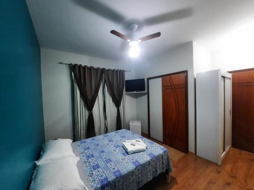Schlafzimmer mit einem Bett und einem Deckenventilator in der Unterkunft Alvorada Guest House in Caxambu