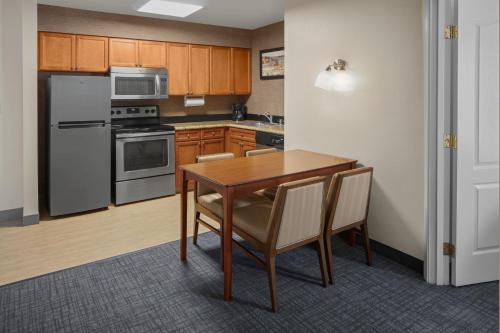 a kitchen with a wooden table and appliances at Residence Inn Manassas Battlefield Park in Manassas