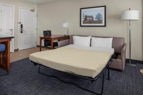 a bedroom with a bed and a couch and a desk at Residence Inn Manassas Battlefield Park in Manassas