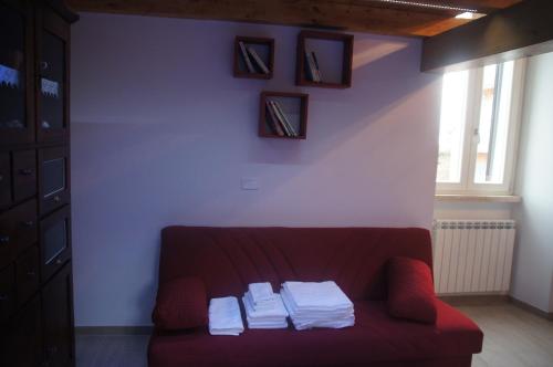salon z czerwoną kanapą i ręcznikami w obiekcie Casa vacanze Albano w mieście Albano Laziale