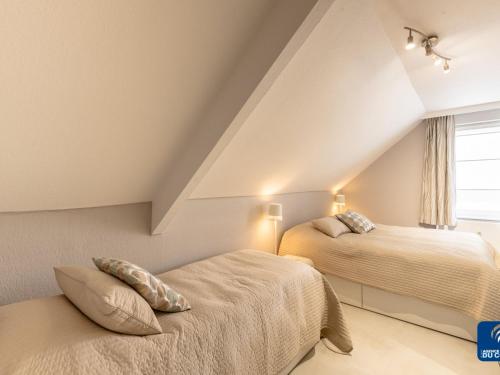 een slaapkamer op zolder met 2 bedden en een raam bij Manderley 0301 very well located in De Haan