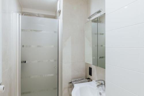 een badkamer met een glazen douche en een wastafel bij Manderley 0301 very well located in De Haan