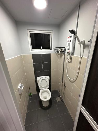 a small bathroom with a toilet and a shower at Be Right Back Homestay in Bukit Mertajam