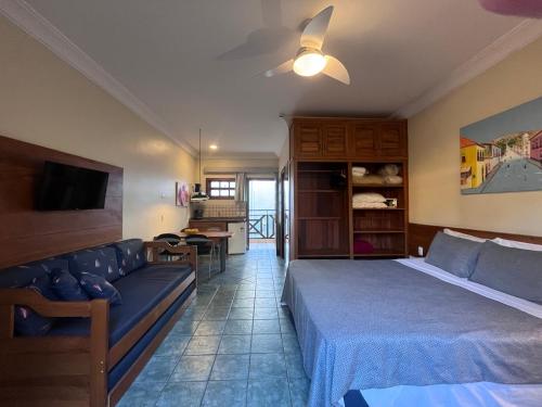 um quarto de hotel com uma cama e um sofá em Suíte 1210 em Flat frente ao mar em Ilhabela