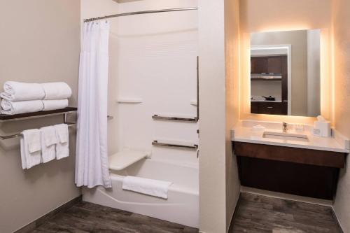 W łazience znajduje się wanna, umywalka i lustro. w obiekcie TownePlace Suites by Marriott San Bernardino Loma Linda w mieście Loma Linda