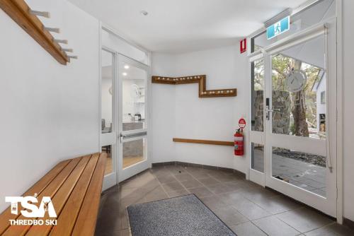 a hallway with a staircase and a glass door at Chalet 26 in Thredbo