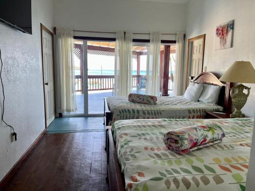 a hotel room with two beds and a balcony at Fosters West Bay Resort in West Bay