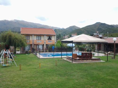 a swimming pool with a tent and a house at Cabañas Lunas y Soles in Potrero de los Funes