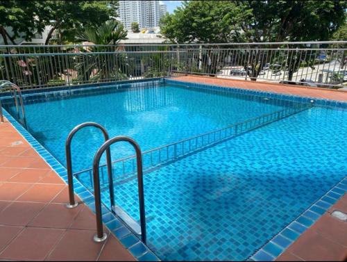 a large blue swimming pool with two metal rails at Spice Arena Guesthouse in Bayan Lepas