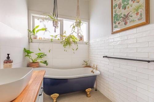 a white bathroom with a tub and a sink at Mena-close to Ballarat CBD, self check-in with bath and cot in Ballarat