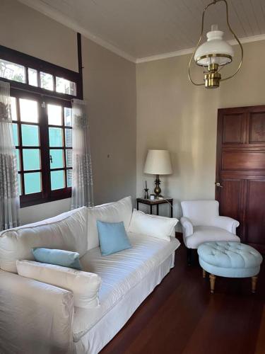 a living room with a white couch and two chairs at Villa Tamen - Colonia in Colonia del Sacramento