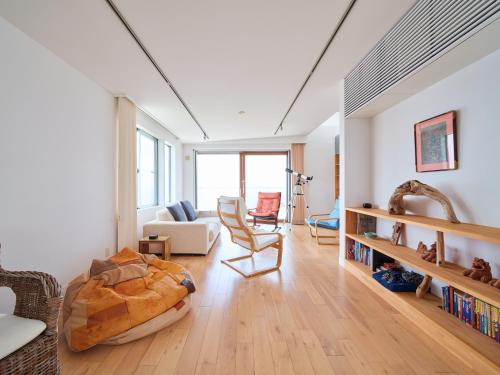 a room with a bed and a living room with a couch at Minami Hayama DAG at ZEE - 南葉山 ダグ アット ジー in Hayama