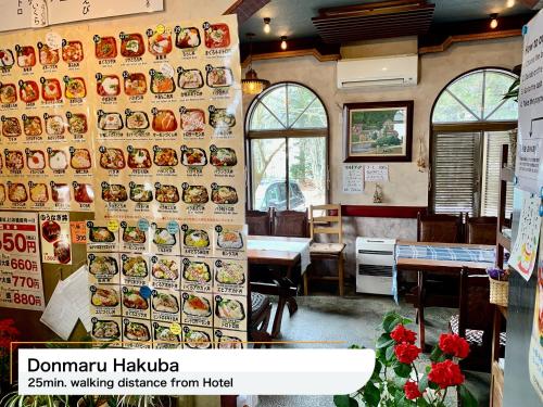 a restaurant with a wall with plates of food on it at Hakuba Park Hotel in Hakuba