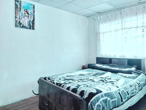 um quarto com uma cama grande num quarto com uma janela em La Casona NiDo de ORO em Oropesa
