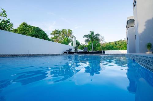 una piscina de agua azul frente a un edificio en Serenity Haven - Your Ultimate Runaway Bay Escape en Runaway Bay