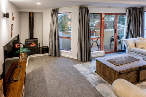 a living room with a couch and a fireplace at Magnificent Apartment with Great Views! in Queenstown