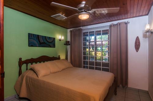 1 dormitorio con 1 cama en una habitación con ventana en Villa Jaco Sol, en Jacó