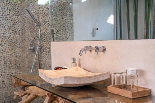 un bagno con lavandino in pietra su un bancone di Villa Charles Ubud ad Ubud