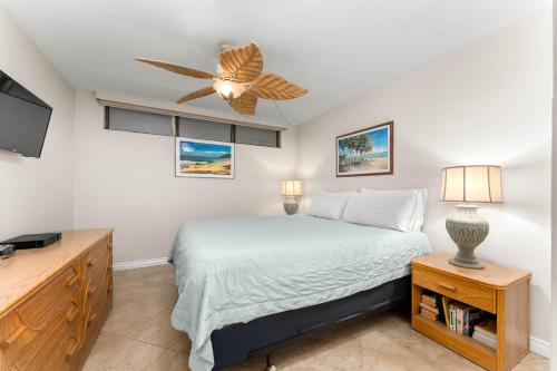 une chambre avec un lit et un ventilateur de plafond dans l'établissement Kihei Akahi D-104, à Wailea