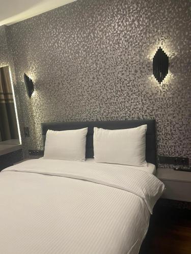 a bedroom with a bed with white sheets at Uzunkum Hotel in Trabzon