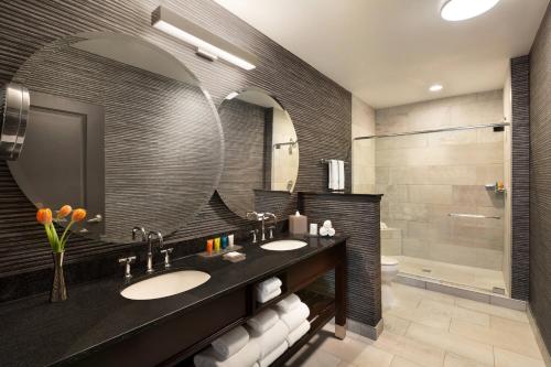 a bathroom with two sinks and a large mirror at Twelve Downtown, Autograph Collection in Atlanta