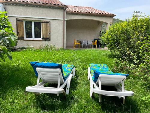 deux chaises longues assises dans l'herbe devant une maison dans l'établissement Le Romulus, à Roumoules