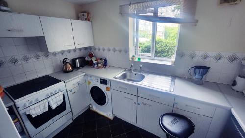 a kitchen with a sink and a washing machine at Lekmic Global in London