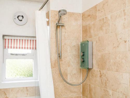 a shower with a green box in a bathroom at Elliot Cottage in Bamburgh