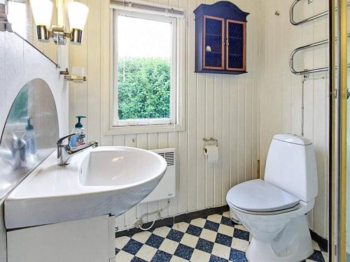 a bathroom with a sink and a toilet and a window at Holiday home Karrebæksminde LIV in Karrebæksminde