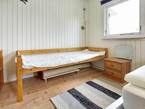 a small bedroom with a bed and a window at Holiday home Karrebæksminde LIV in Karrebæksminde