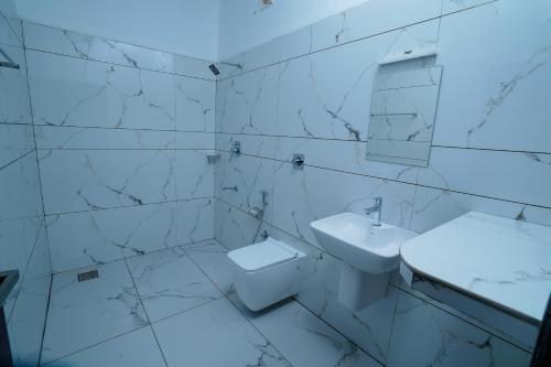 a white bathroom with a sink and a toilet at KOTTACKAL NATURE INN in Angamali