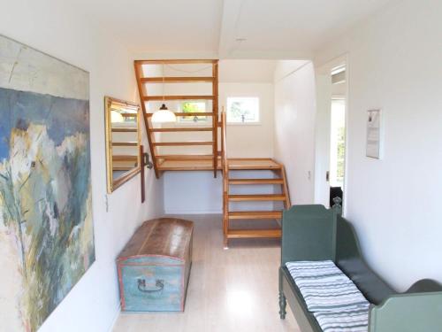 um quarto com um beliche, um sofá e escadas em Holiday home Svaneke II em Svaneke