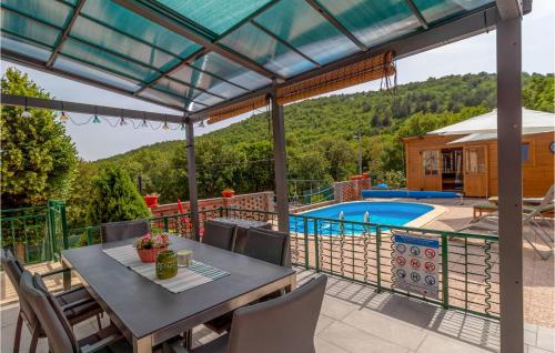 a patio with a table and chairs and a swimming pool at Beautiful Home In Ledenice With Sauna in Ledenice